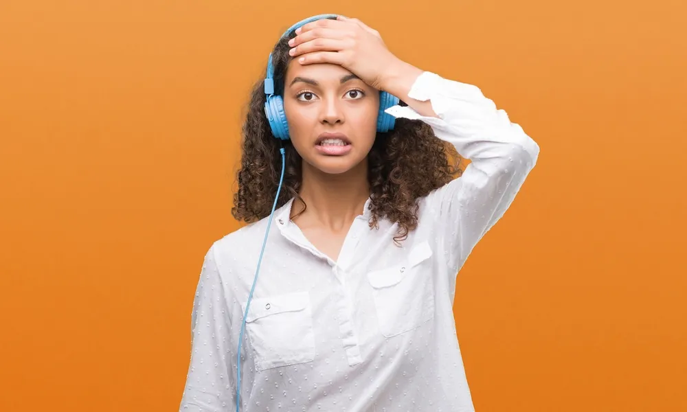 Frustrated language learner wearing headphones, struggling with pronunciation practice