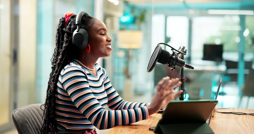 Woman with headphones actively practising pronunciation by speaking into a microphone